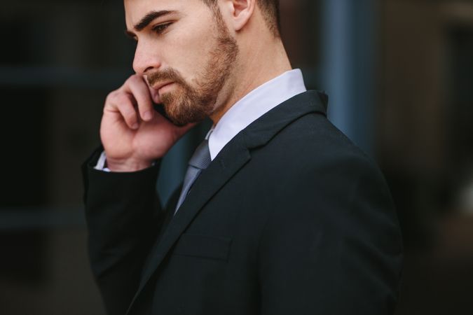 Side view close up of businessman talking over mobile phone