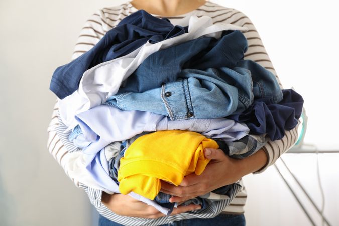 Young woman hold crumpled clothes, space for text