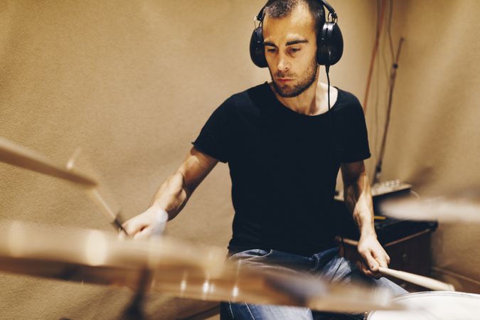 Man with headphones playing on drums