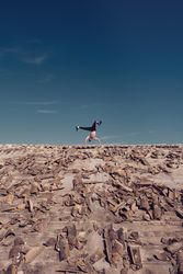 Anonymous man dancing breakdance on rooftop in sunny day