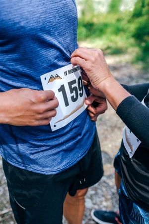 Trail athlete placing race number to her partner