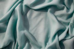 Nude green fabric wavy crumpled background texture with copy space.
