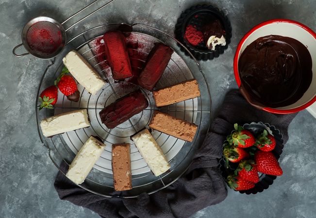 Chocolate and strawberry cakes near bows with ingredients