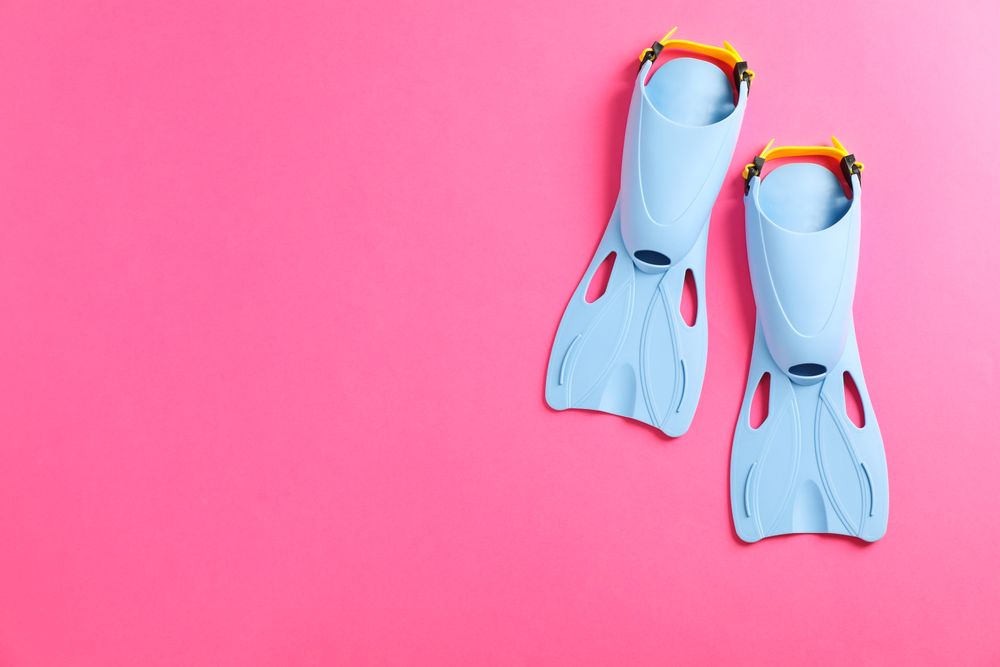 Blue flippers on pink background, space for text