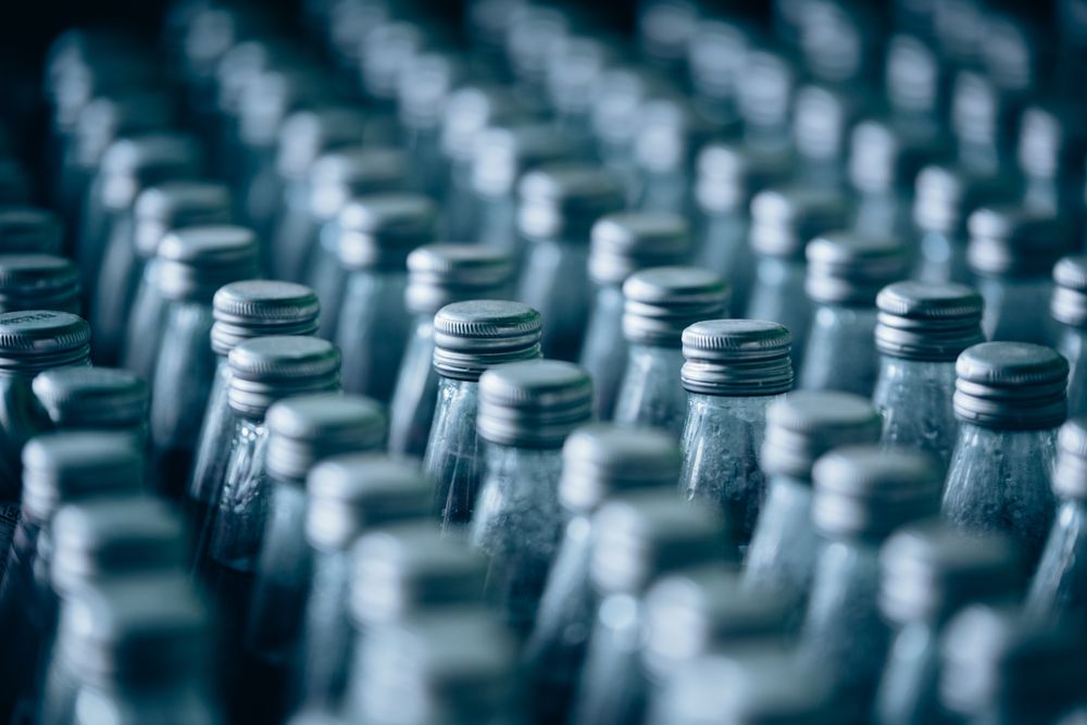 Multiple bottles of fruit juice are arranged in rows, creating a colorful and organized background.