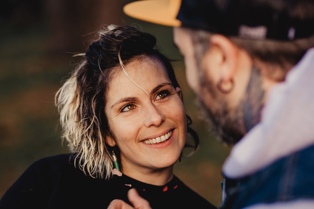 Happy couple hugging near tree in park