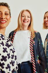 Three happy older women standing together in studio portrait