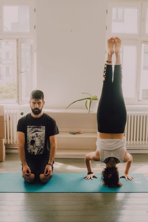 Sportive couple meditating together at home