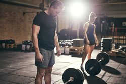 Two crossfit trainers preparing to lift heavy weights