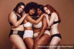 Multi-ethnic group of females with arms on each other’s shoulders posing in lingerie 41NQ8b