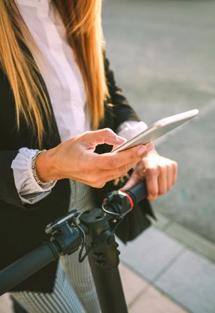 Detail of mobile of businesswoman with electric scooter