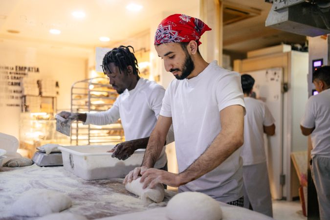Young Middle Eastern & Black baker working on dough