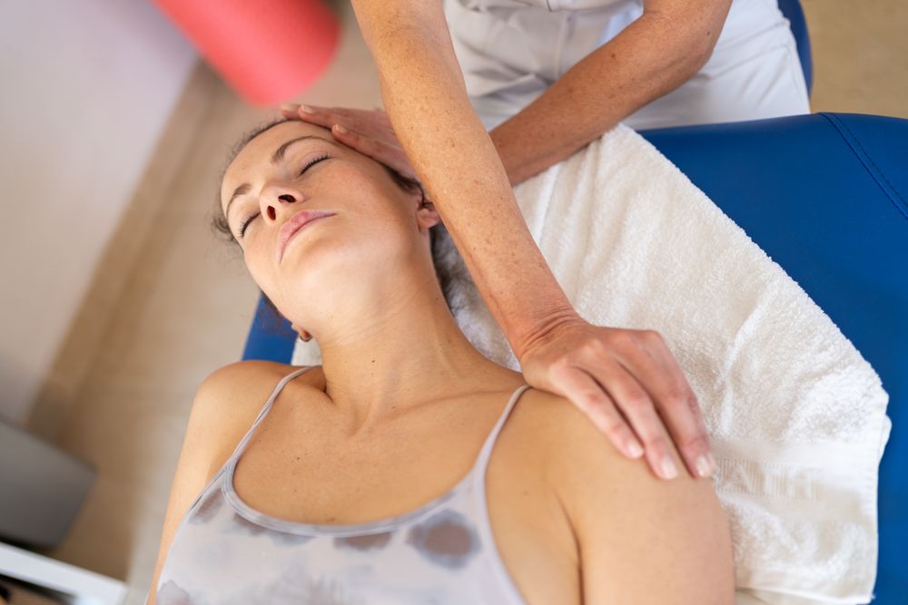 Physiotherapist stretching neck of client in clinic