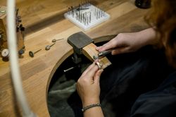 unrecognizable woman grinding ring in jewelry atelier
