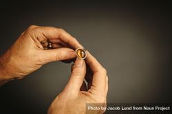 Close up of female jewelry maker hands examining silver ring 4d1nLb