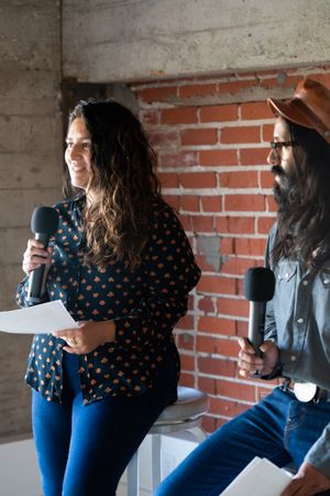 Man and woman holding microphones while public speaking