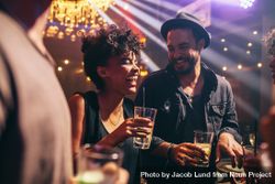 Happy young man and woman having drinks and smiling in nightclub 5REVW0