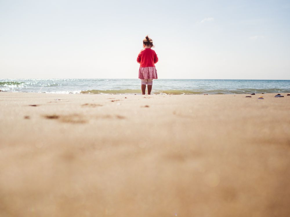 Girl walking on beach in sunny day