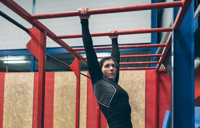 Sportswoman exercising on monkey bars