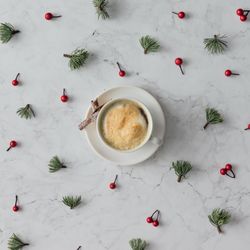 Holly and pine pattern on marble background with coffee