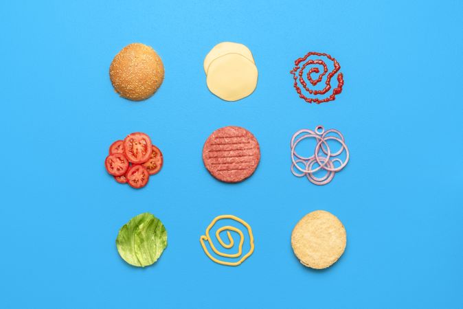 Burger ingredients top view isolated on blue background