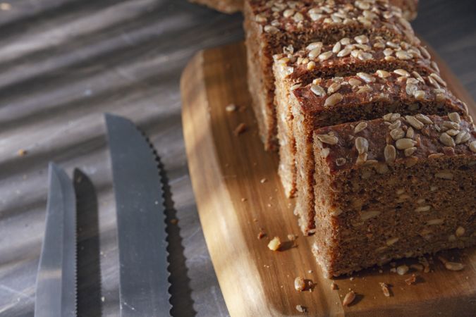 Sliced wholegrain bread on wooden cutting board