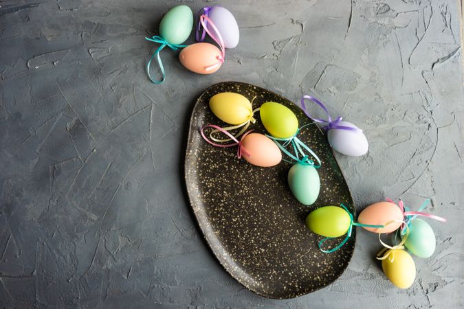 Easter table setting with multicolored decorative eggs on grey background