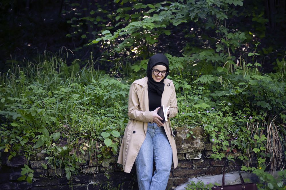 Laughing woman in headscarf with a book