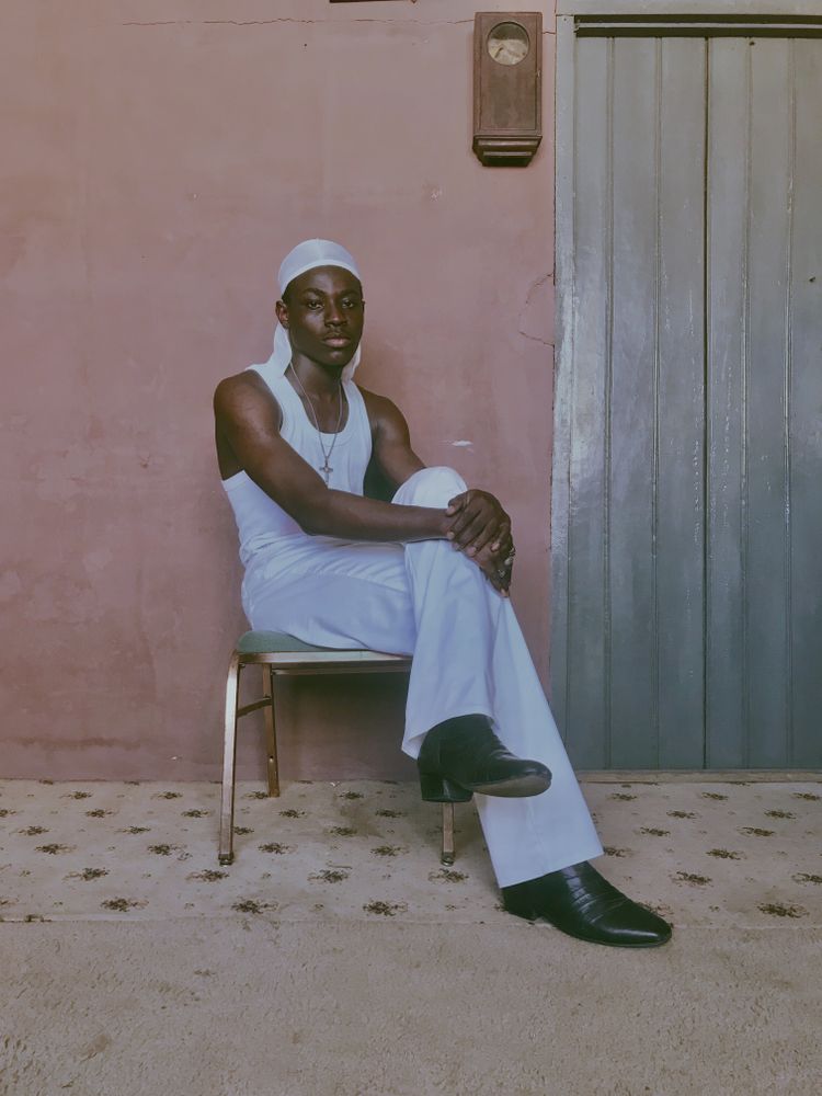 Young man in light bandana sitting on a chair indoor