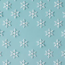 Winter pattern made of uniform snowflakes on blue background