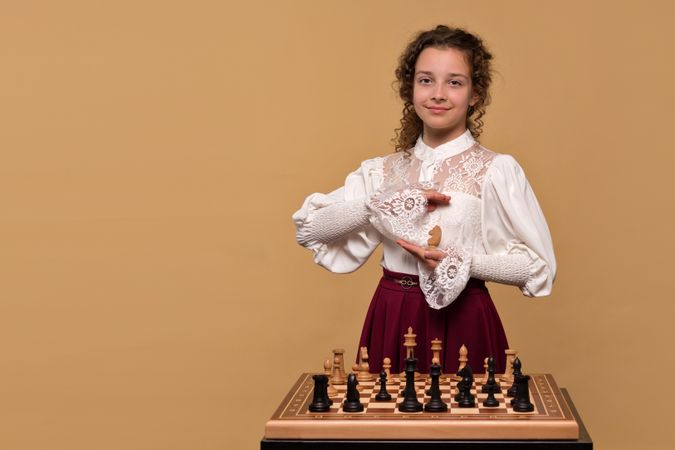Young girl holding white chess knight