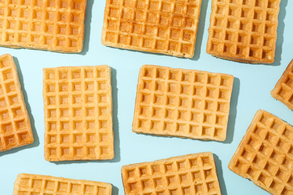 Flat lay composition with belgian waffles on color background