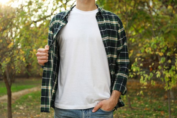 Men in t-shirt and checkered shirt in park, copy space