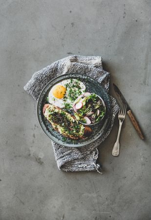 Avocado toast on sourdough bread with herbs and sprouts, on cloth napkin, copy space