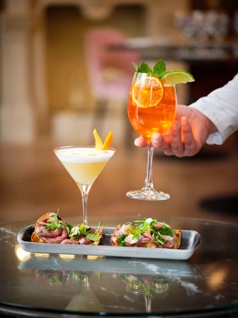 Crop guest taking aperitif cocktail