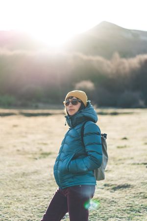 Traveler with backpack walking on autumn field