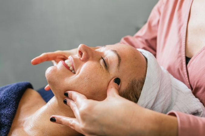 Anonymous masseuse doing massage for woman in spa salon