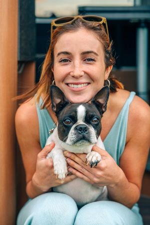Happy woman posing to photo with cute dog, vertical