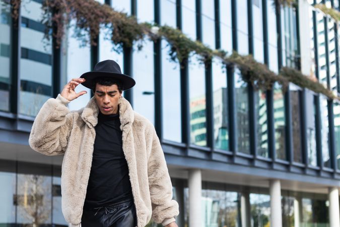 Stylish man reflecting in building on the street