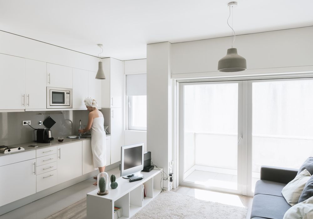 Pensive serene woman having refreshment with water in comfortable kitchen