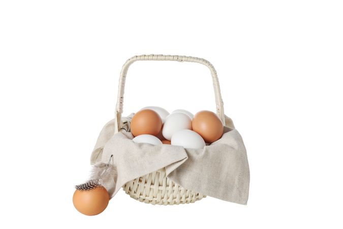 eggs in a wicker basket with handles, isolated on blank background.
