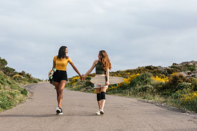 Cheerful diverse women walking on the road