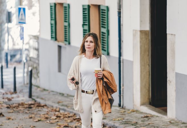Woman walking with cup of coffee
