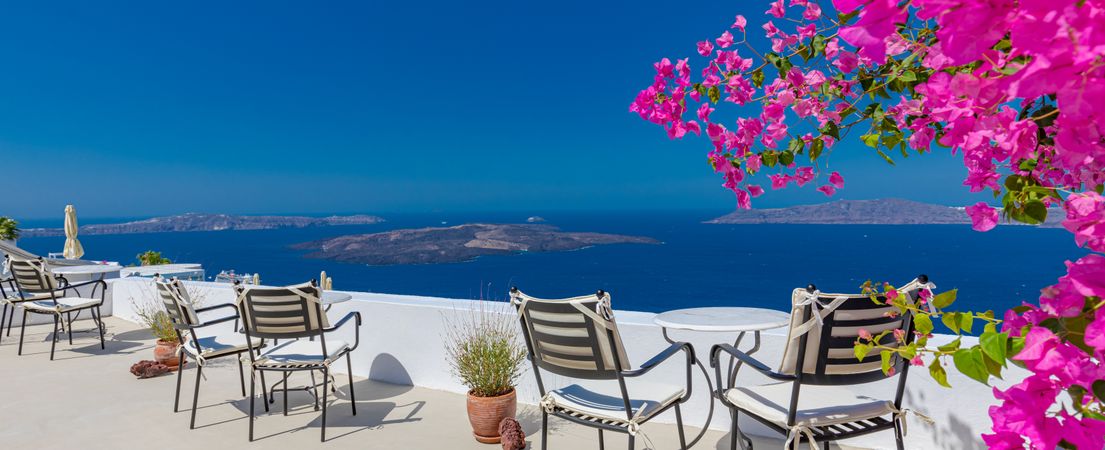Wide shot of patio overlooking the Aegean Sea with empty chairs
