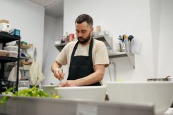 Young chef stirring with cooking rod