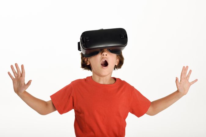 Smiling girl excited by VR glasses and gesturing with arms opened