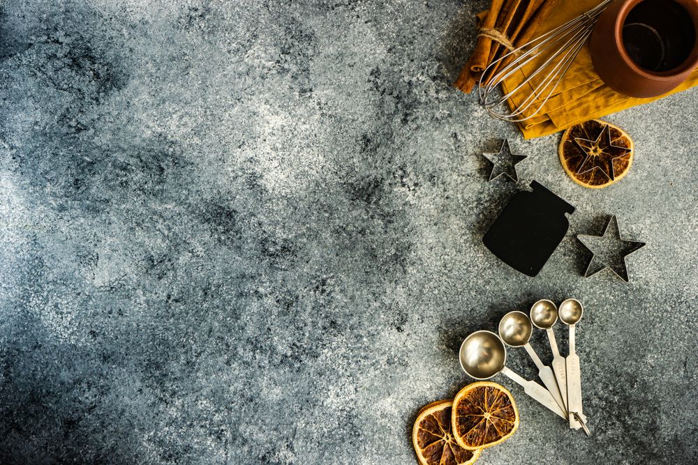 Christmas cookie baking equipment on stone background with copy space