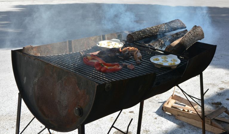 Old school barbecue with meats grilling and eggs frying