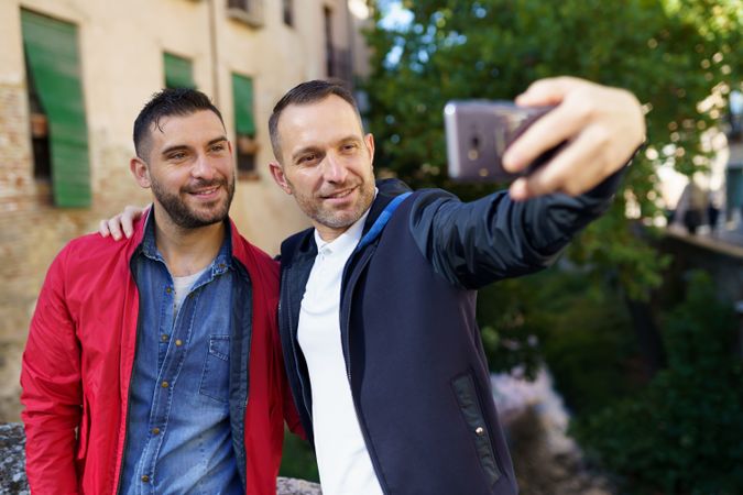 Two calm men taking selfie outside