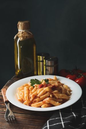 Composition with plate of tasty pasta on wooden background. Cooking pasta